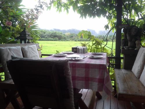 a table with a red and white checkered table cloth at Jamjuree Garden in Ban Thung Ma Nieo