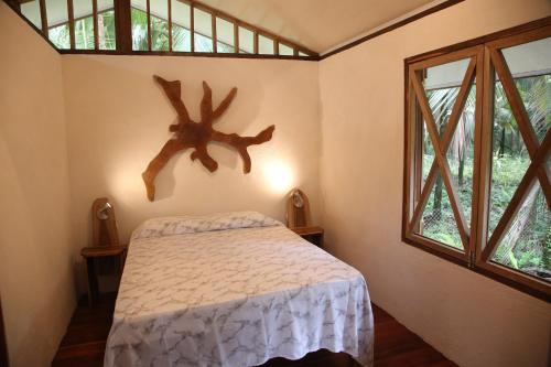 a bedroom with a bed and a large window at Green Corner in Cahuita