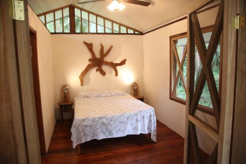 - une chambre dotée d'un lit avec un bois sur le mur dans l'établissement Caribbean Secret, à Cahuita