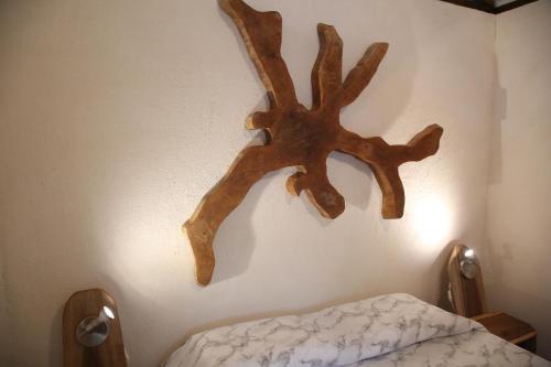 a wall with a wooden antler hanging on a wall at Green Corner in Cahuita