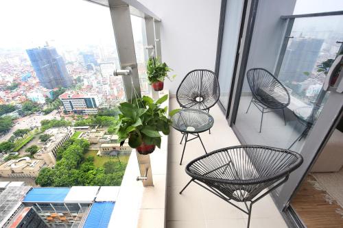 a balcony with three chairs and a view of a city at Vinhomes Metropolis Hanoi - CitiHome in Hanoi