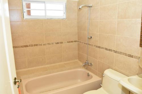 a bathroom with a tub and a toilet and a sink at Uyuca Vista Family Villa in Tegucigalpa