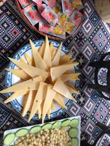 a plate of cheese and vegetables on a table at Mai Chau Sunset Boutique Hotel in Mai Chau