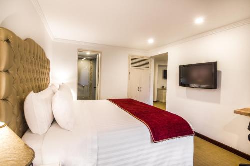 a hotel room with a bed and a television at GHL Hotel Hamilton in Bogotá