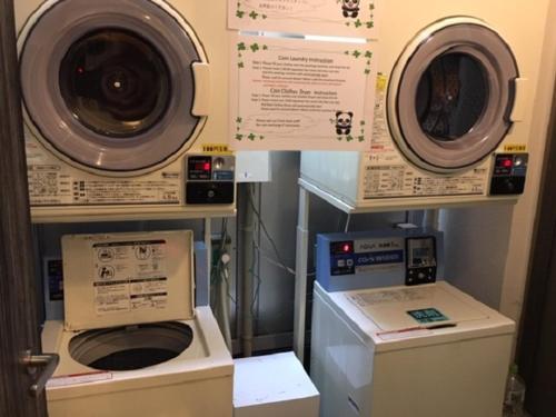 two washing machines and a washer and dryer in a room at Ueno Urban Hotel in Tokyo