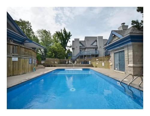 a large blue swimming pool in front of a house at Slopeside Blue Mountain Condo - Wifi, Linens/Towels, Ski In/Out in Blue Mountains