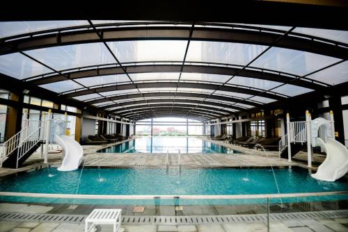 a large swimming pool with slides in a building at Vinhomes Metropolis Hanoi - CitiHome in Hanoi