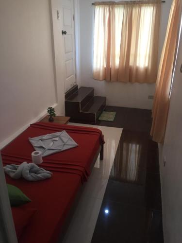a bedroom with a red bed and a few boxes at Raje Residence in El Nido