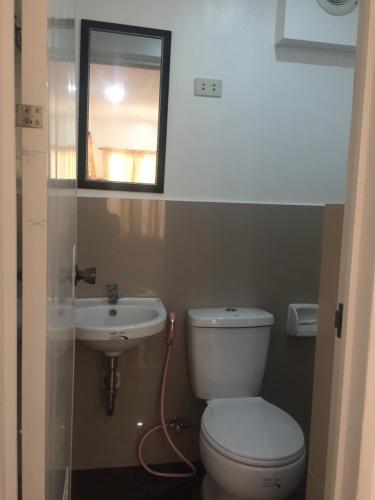 a bathroom with a toilet and a sink and a mirror at Raje Residence in El Nido