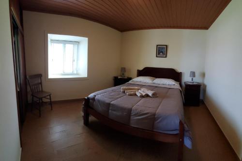 Faja GrandeにあるCasa Fagundesのベッドルーム1室(ベッド1台、動物2匹の詰め物付)