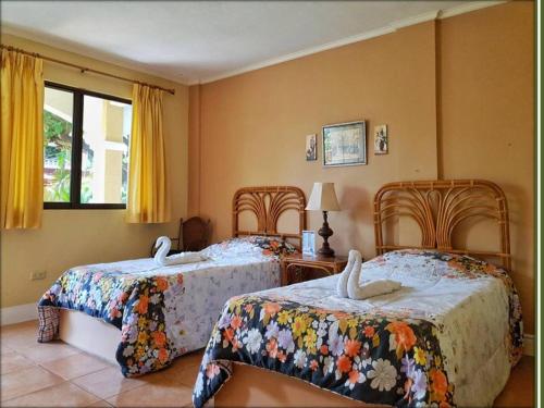 a bedroom with two beds with white swans on them at Playa Papagayo Beach Inn in Olongapo