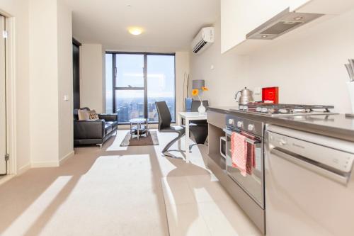 a living room with a kitchen and a dining room at Melbourne SkyHigh Apartments in Melbourne
