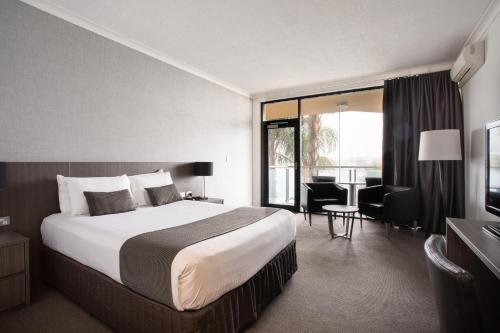 a hotel room with a bed and a large window at Lakes Hotel in Adelaide