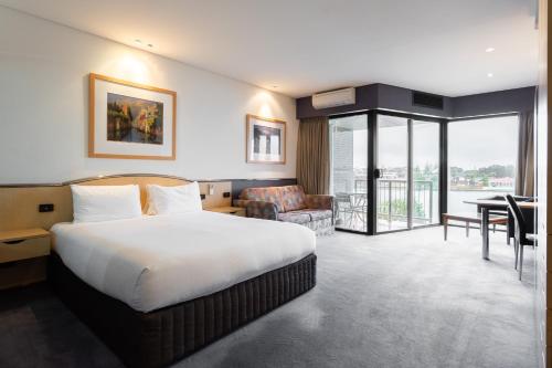 a hotel room with a large bed and a desk at Lakes Hotel in Adelaide