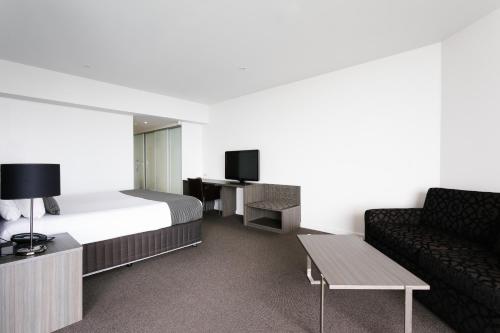 a hotel room with a bed and a couch at Lakes Hotel in Adelaide