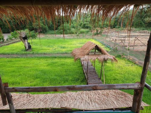 ein Grasdach mit einem Grasfeld in der Unterkunft Supalai Pasak Resort Hotel And Spa in Kaeng Khoi