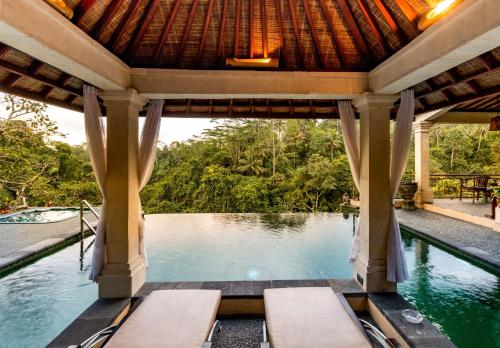 an infinity pool in a villa at a resort at Tanah Merah Art Resort by AGATA in Ubud