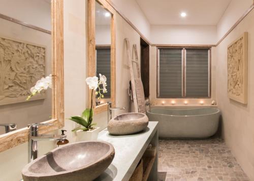 a bathroom with a large tub and a sink and a bath tub at Aloha Beach House Bingin in Uluwatu