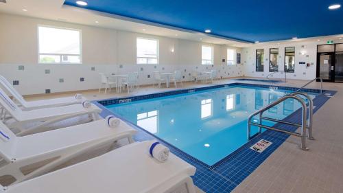 una gran piscina con sillas y mesas en Best Western Plus Hinton Inn & Suites en Hinton