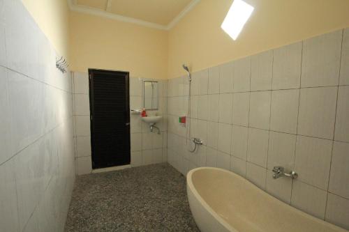 a bathroom with a bath tub and a sink at Ayuna Family Ubud in Ubud