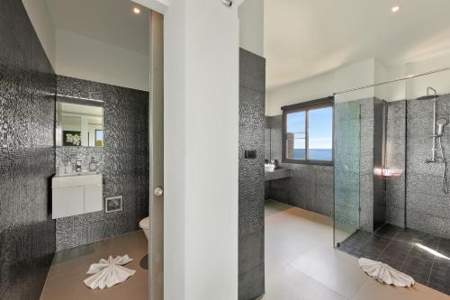 Un baño con ducha de cristal y lavabo. en Ban Nai Fan - Private Pool Villa, en Choeng Mon Beach