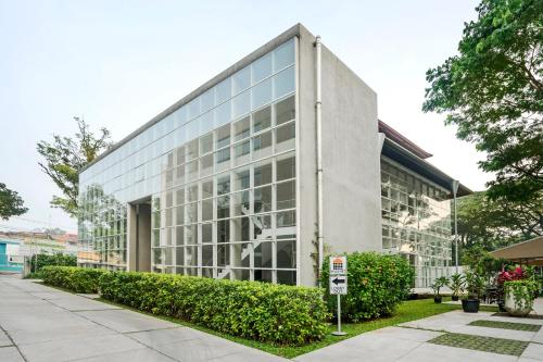 a large glass building with a parking meter in front of it at Malaka Hotel Bandung in Bandung