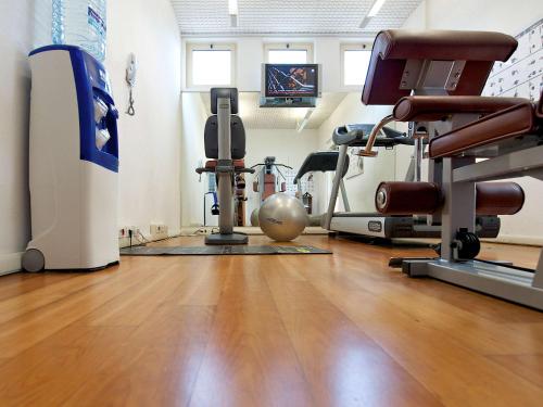 a gym with a wooden floor and exercise equipment at Novotel Roma Est in Rome