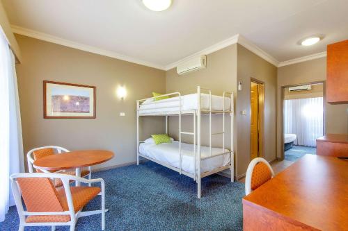 a room with a bunk bed and a table at Quality Inn Penrith Sydney in Penrith
