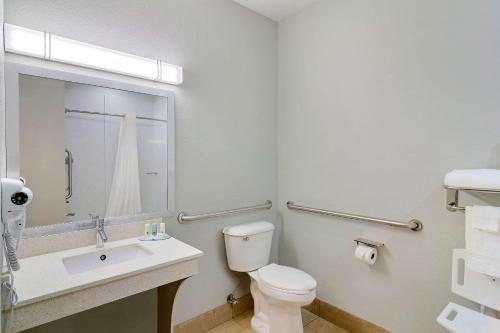 a bathroom with a toilet and a sink and a mirror at Quality Inn & Suites Decatur - Atlanta East in Decatur