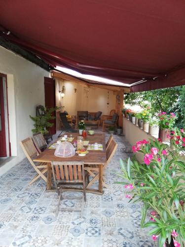 un patio avec une table et des chaises en bois dans l'établissement LA MAISON DE MARION, à Tournus