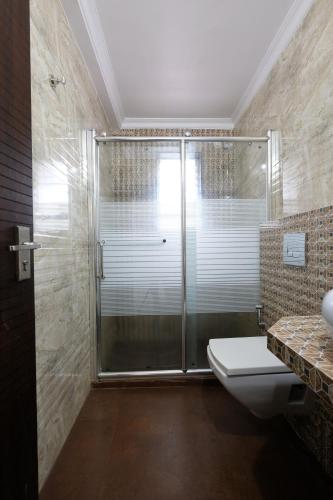 a bathroom with a glass shower and a toilet at Nishka holiday home in Candolim