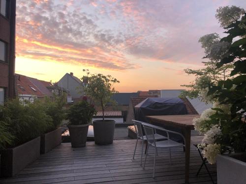 a wooden deck with a table and chairs on a balcony at Desk Till Dawn in Ghent