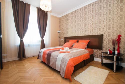 a bedroom with a bed with orange pillows and a window at Apartment on Tverskaya in Moscow