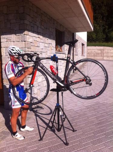 a man is holding a bike on a stand at Mortirolo in Mazzo di Valtellina