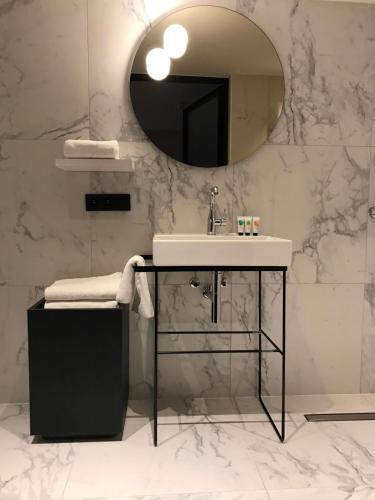 a bathroom with a sink and a mirror at Amosa Liège City Centre Hotel in Liège