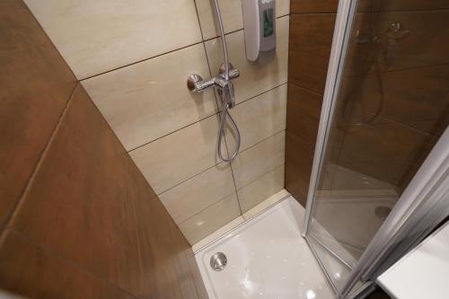 a shower stall with a glass door with a shower at Hotel Montpensier in Paris