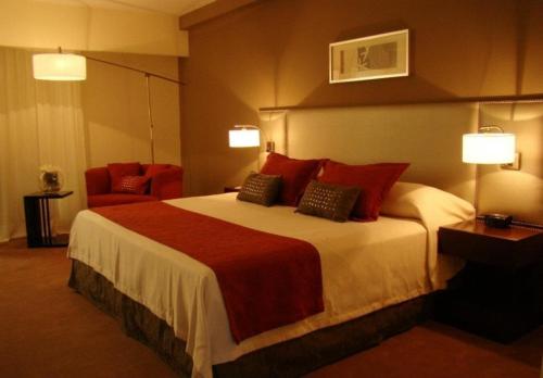 a hotel room with a large bed with red pillows at Howard Johnson Hotel & Casino in Formosa