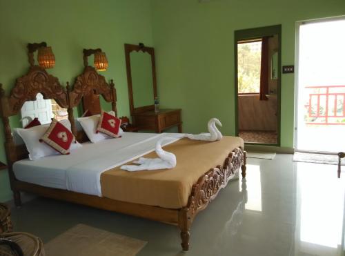a bedroom with a large bed with swans on it at Panthalams Homestay in Thekkady
