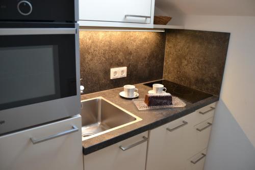 a kitchen with a sink and a cake on a counter at Gästehaus Elisabeth in Radstadt