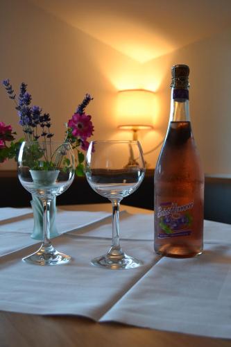 a bottle of beer and two wine glasses on a table at Gästehaus Elisabeth in Radstadt