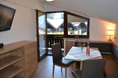 a dining room with a table and chairs and windows at Gästehaus Elisabeth in Radstadt
