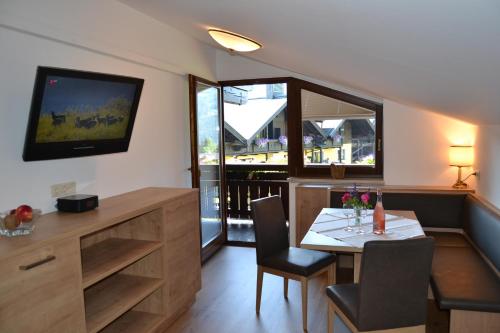 a small dining room with a table and a television at Gästehaus Elisabeth in Radstadt