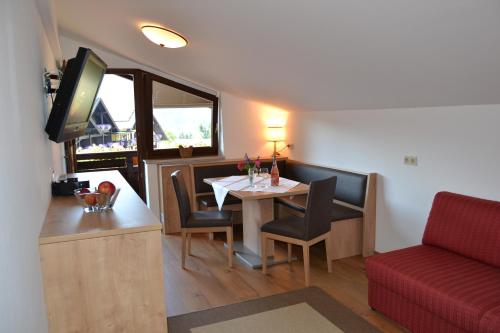 a small dining room with a table and a red couch at Gästehaus Elisabeth in Radstadt