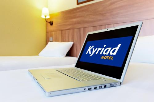 a laptop computer sitting on top of a bed at Kyriad Auray in Auray