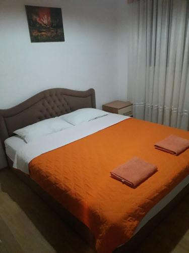 a bedroom with a large bed with an orange blanket at Bochkar Guest House in Ohrid