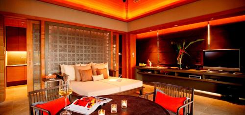 a living room with a white couch and a television at Sri Panwa Phuket Luxury Pool Villa Hotel - SHA Plus in Panwa Beach