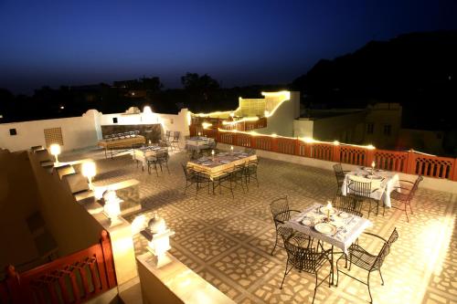 an outdoor patio with tables and chairs at night at Khatu Haveli in Jaipur