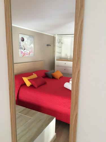 a red bed in a small room with a mirror at Casa Vacanza Mar' illù in Castellammare del Golfo