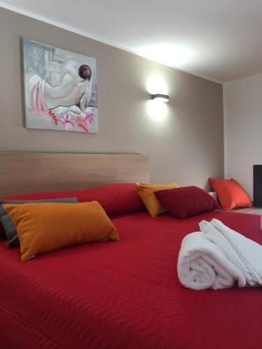 a bedroom with a large bed with red and orange pillows at Casa Vacanza Mar' illù in Castellammare del Golfo