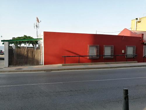 a red building on the side of a street at Apartamentos Playa Benitez in Ceuta
